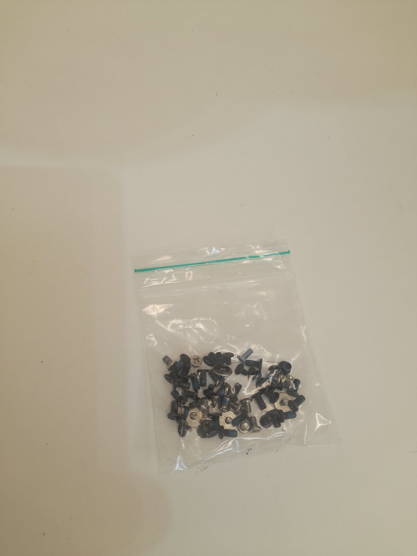 Small black objects in a clear plastic bag on a beige background