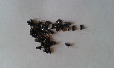 A collection of various sized metal screws, presumably for internal and external use in a Dell XPS 15 L501X laptop.